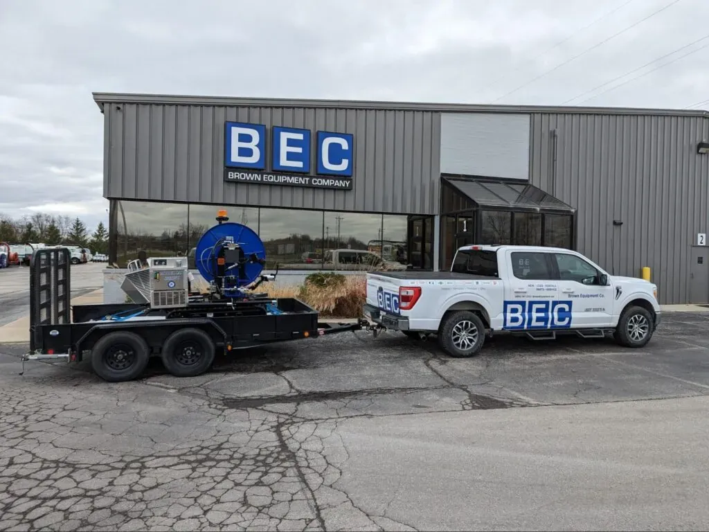 BEC company truck and trailer holding. Sewer easement machine parked outside their modern building.