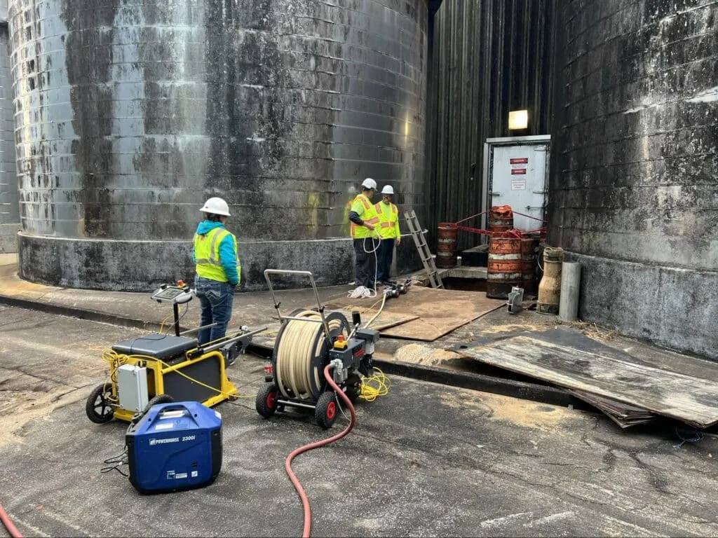 Workers in safety gear conducting maintenance at an industrial facility.
