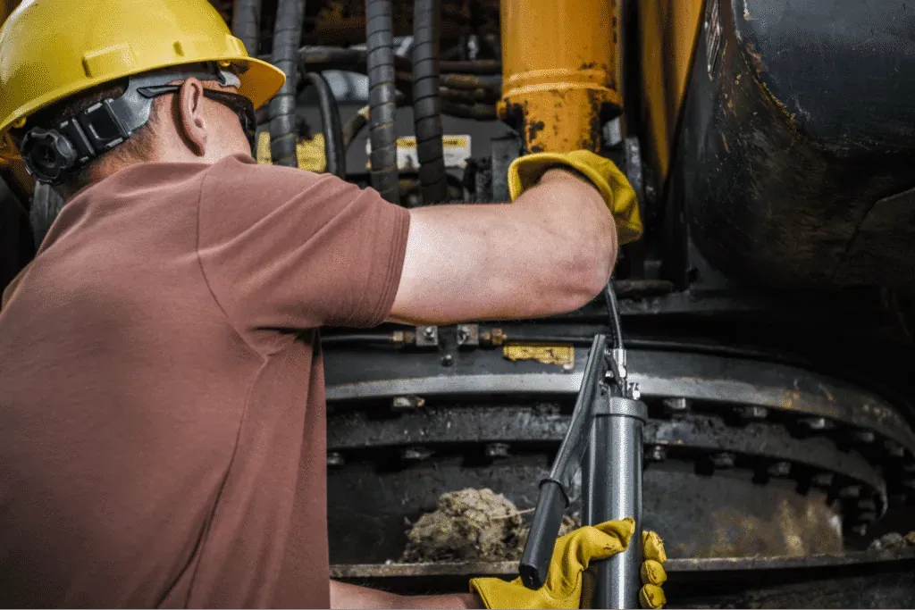 equipment reliability concept with utility worker performing maintenance on heavy machinery