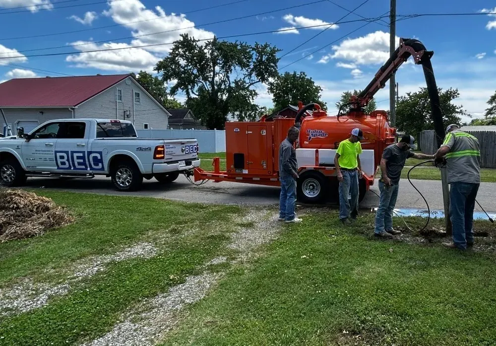 Crew performing plumbing maintenance on a job site with hydro excavation equipment