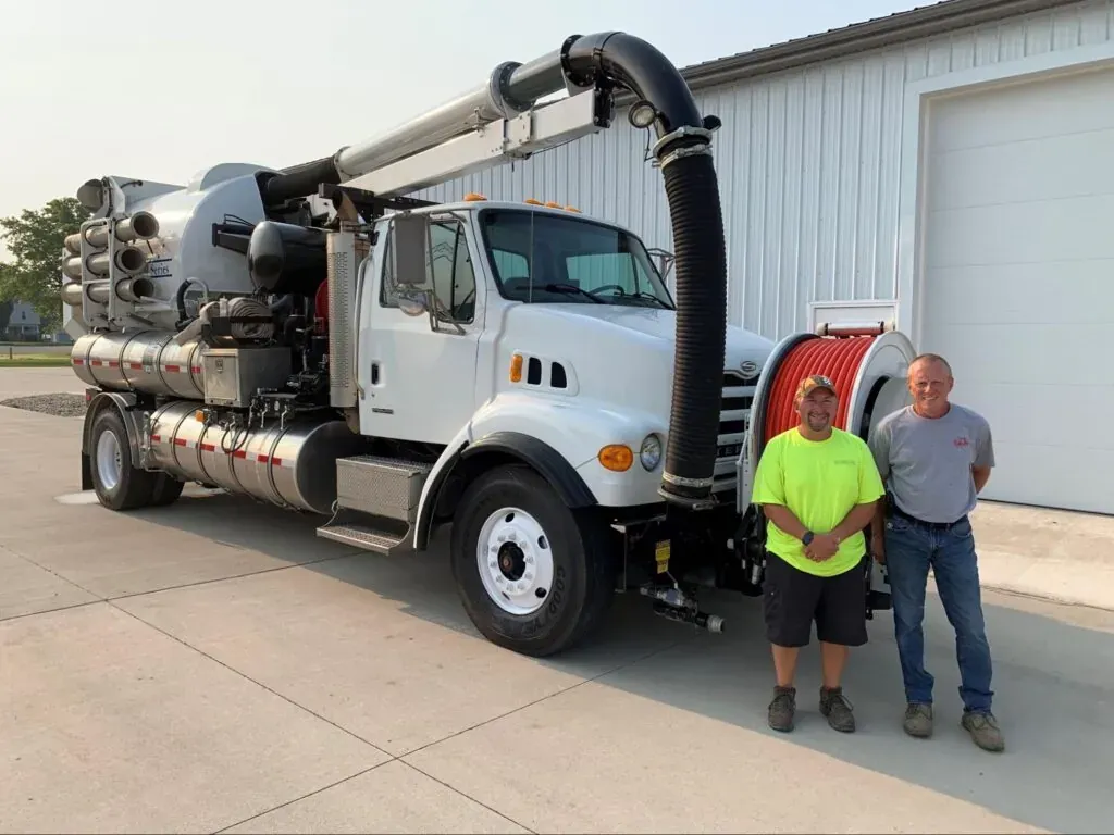 Two vacuum truck operators with equipment ready for hire.