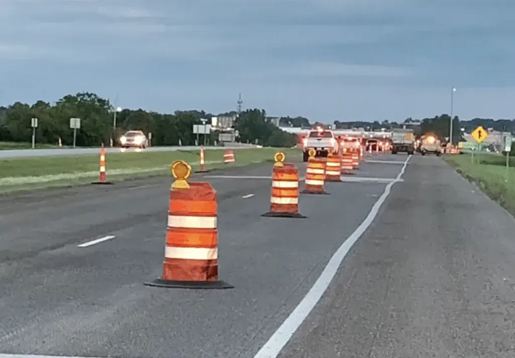 Safety orange barrels marking roadwork area on a highway for heavy equipment operations