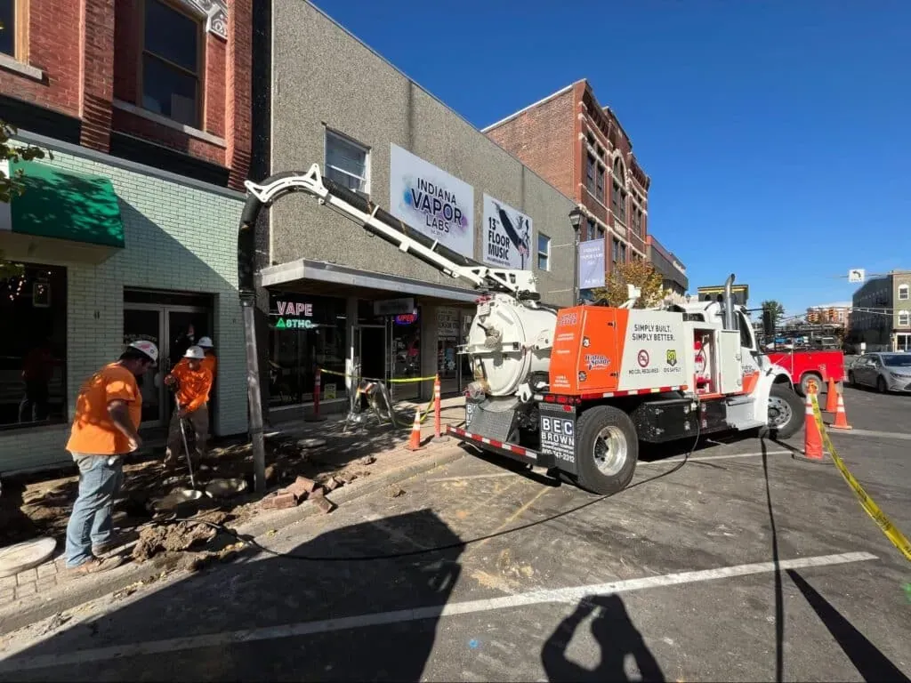 Downtown street repair work with heavy machinery and construction workers.