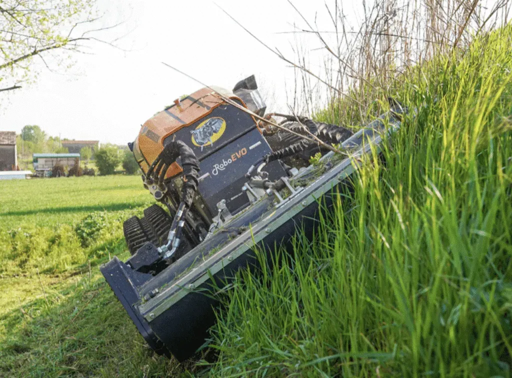 Slope mower tackling overgrown grass in a active green field.