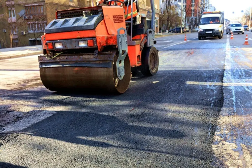 Asphalt roller working on road improvement project.