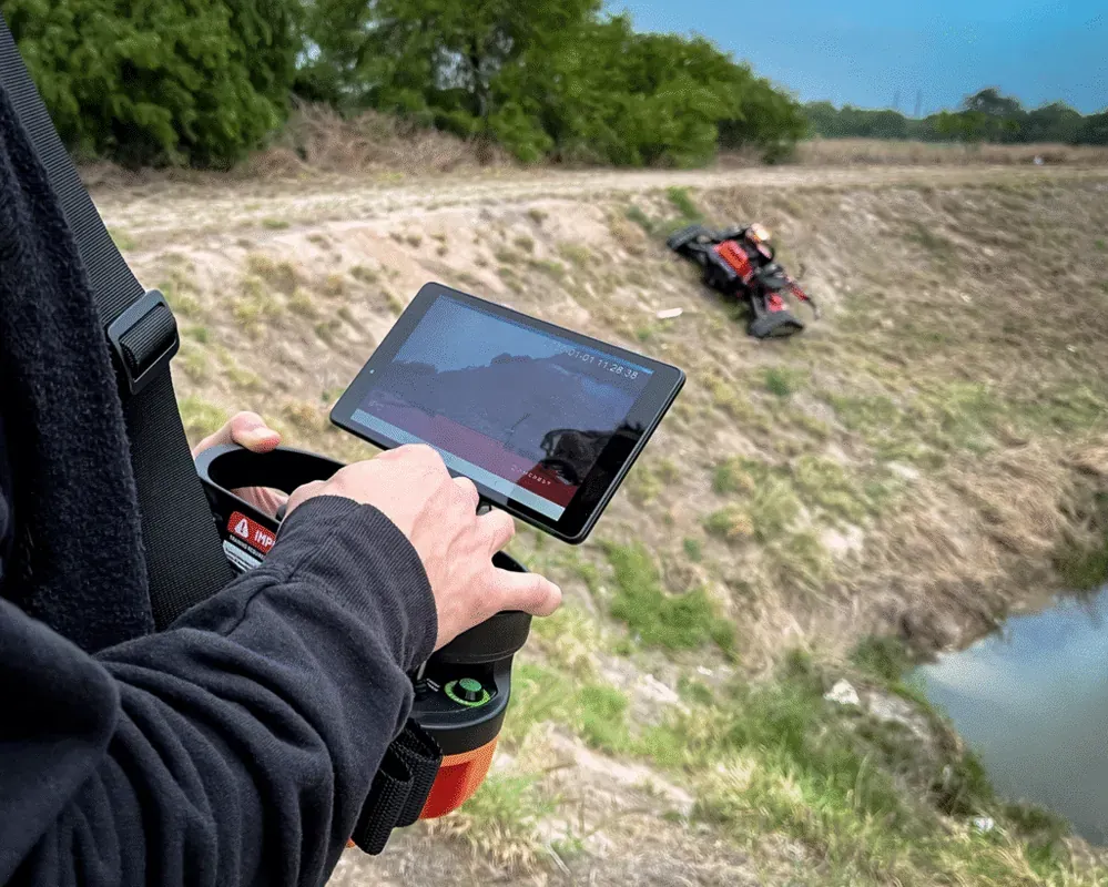 Operating a remote slope mowers on uneven terrain using a handheld device.