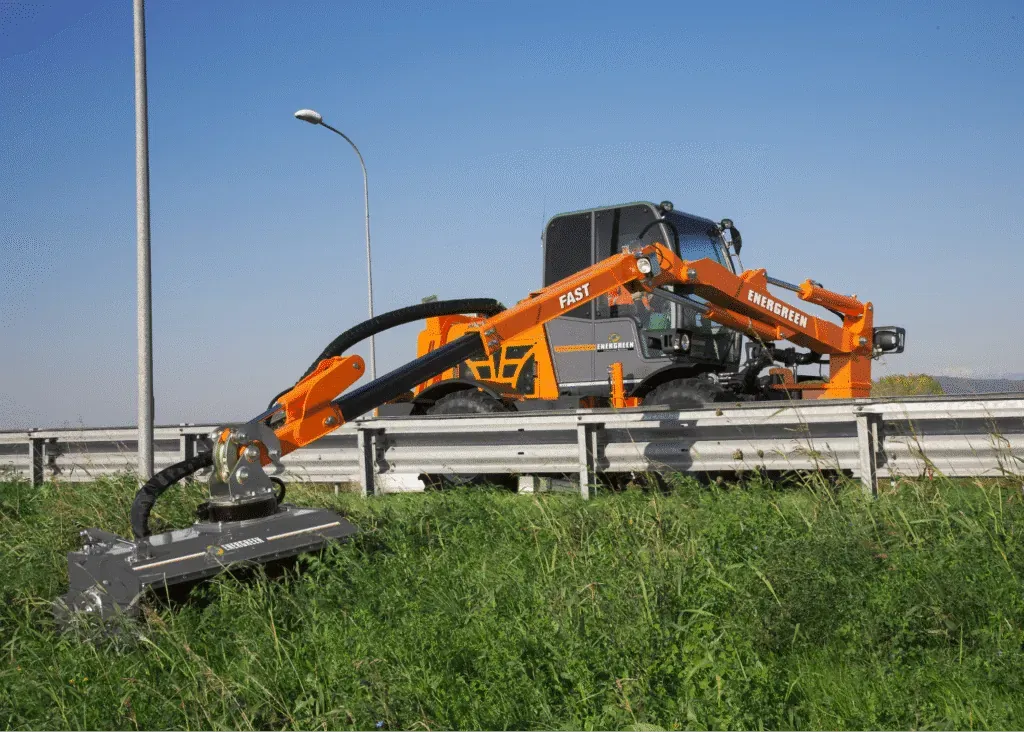 High-tech roadside mower trimming grass near a highway for optimal maintenance.