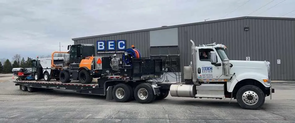 Heavy machinery loaded on truck for transport at BEC facility.